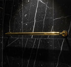 Gold towel bar on a black marble wall