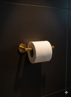 Roll of toilet paper on a gold holder against a dark wall