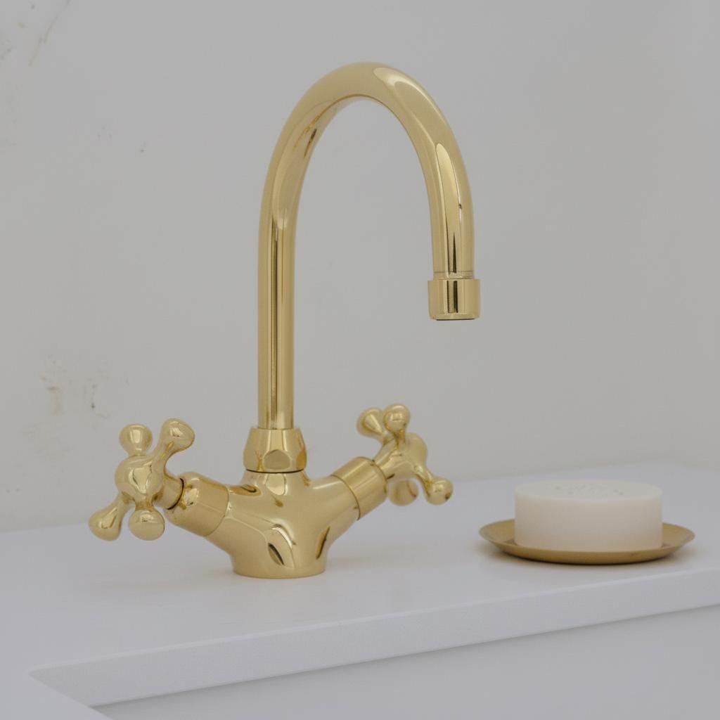 Gold faucet on a white sink with a bar of soap in the background
