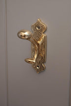 Decorative gold door handle on a gray door
