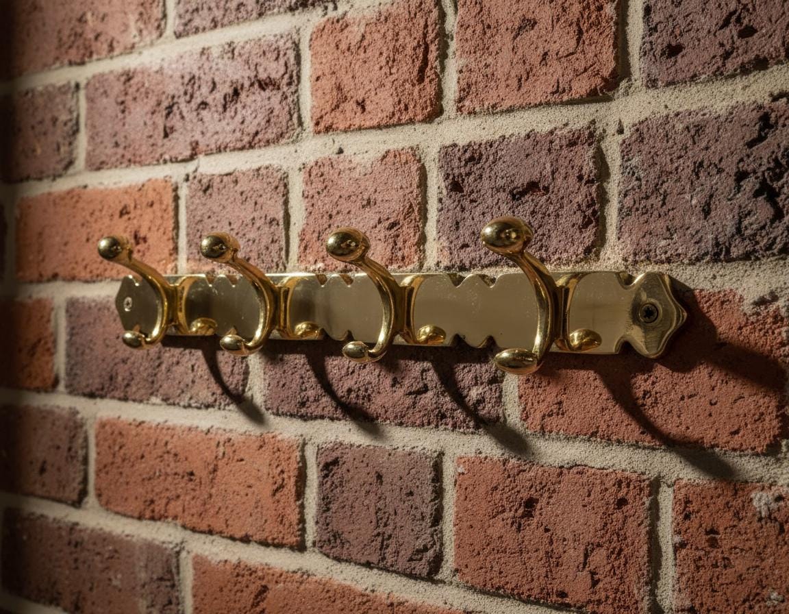 Gold wall hook with multiple hooks on a brick wall