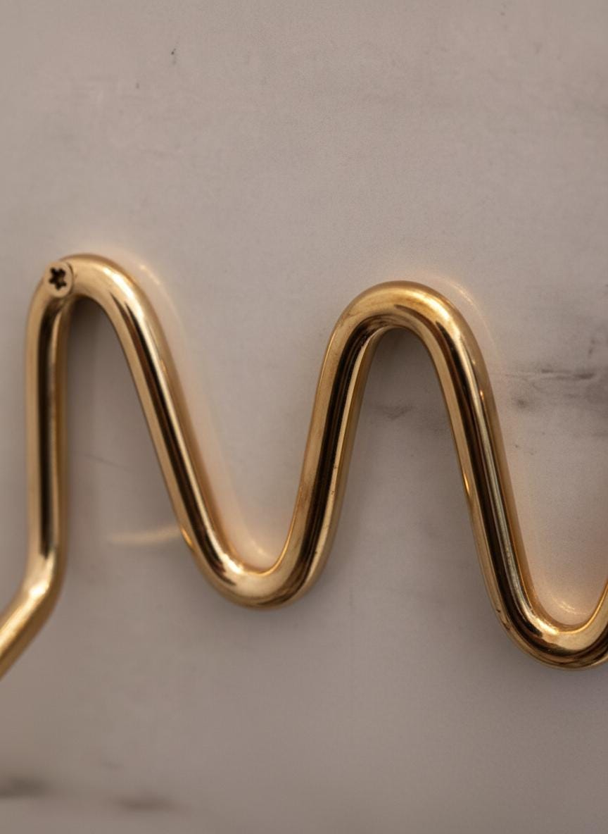 Gold wavy earring on a light background