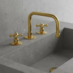 Gold faucet and handles on a gray stone sink