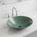 Teal glass sink on a marble countertop with a white tiled wall background