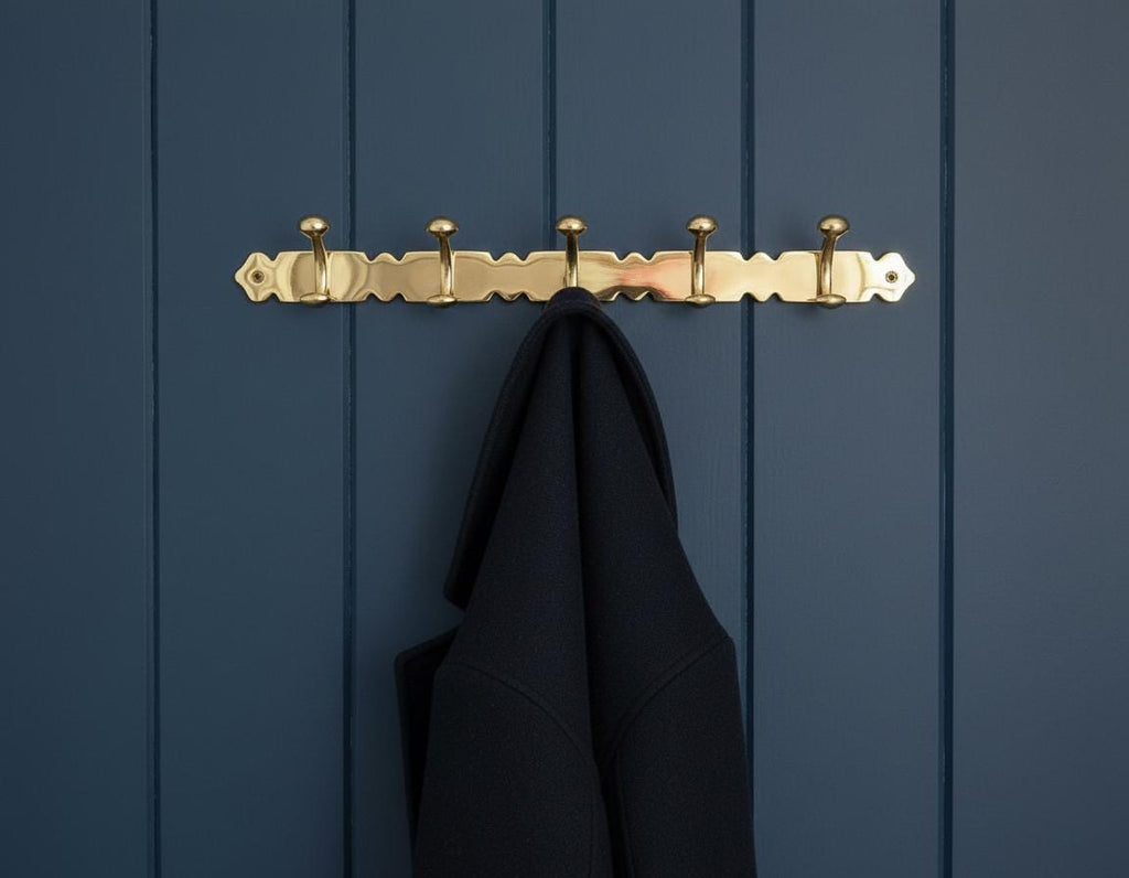 Gold hook with a black coat on a blue wooden panel background