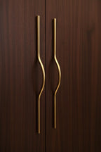 Gold cabinet handles on a dark wooden door