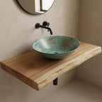 Turquoise mosaic sink on a wooden shelf with a black faucet in a bathroom setting.
