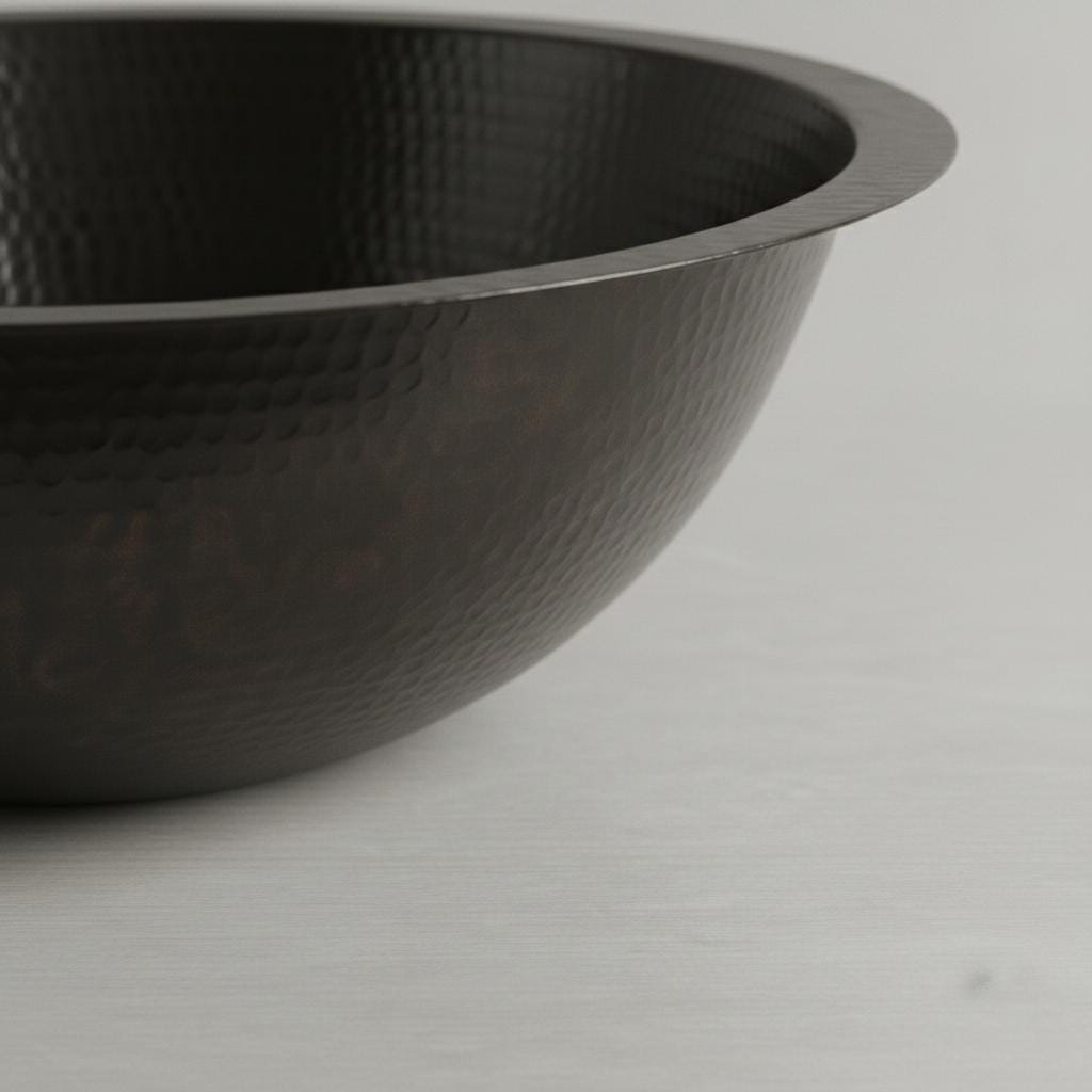 Black metal sink with textured surface on a light gray background