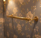 Gold towel bar on floral-patterned wall