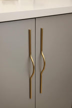 Gray cabinet with gold handles in a kitchen setting