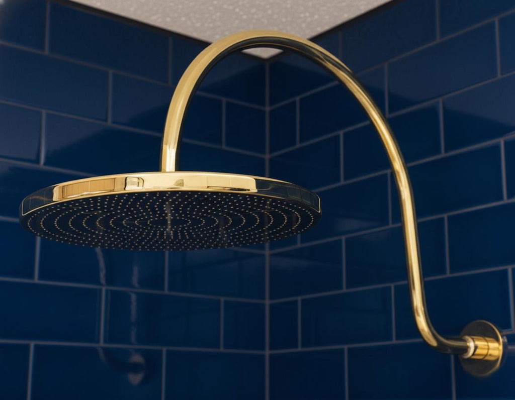 Unlacquered solid brass gooseneck shower arm with round rainfall showerhead for a luxurious bathroom finish