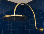 Unlacquered solid brass gooseneck shower arm with round rainfall showerhead for a luxurious bathroom finish