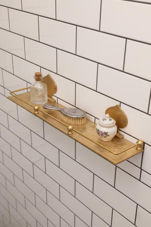 Wooden shelf with decorative items against a tiled bathroom wall