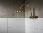 Unlacquered solid brass gooseneck shower arm with round rainfall showerhead for a luxurious bathroom finish