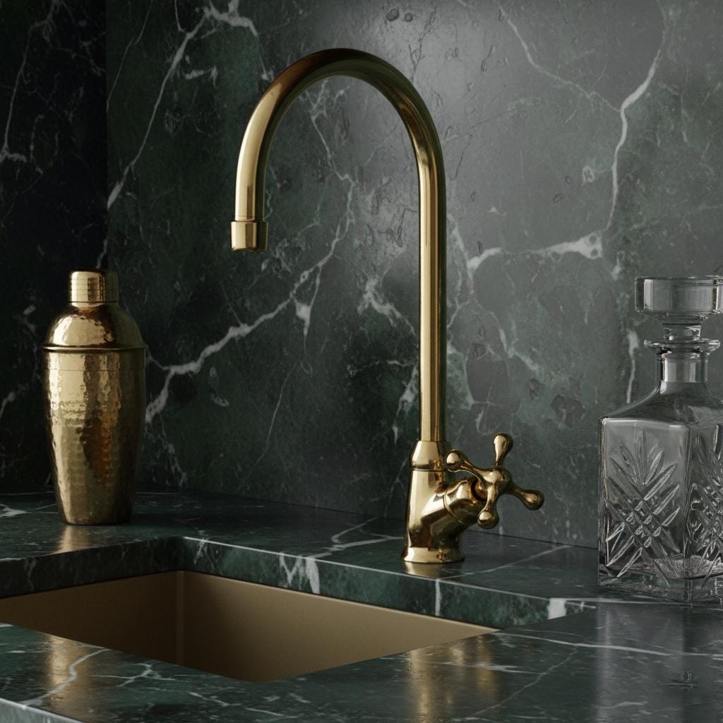 Gold faucet on a marble countertop with decorative bottles.