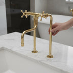 Gold faucet on a marble countertop with a blurred background