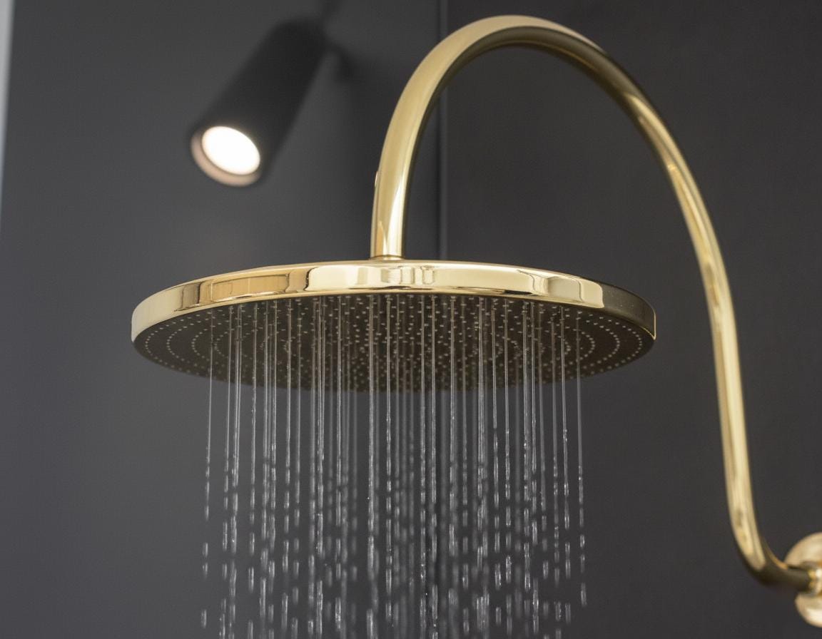 Unlacquered solid brass gooseneck shower arm with round rainfall showerhead for a luxurious bathroom finish