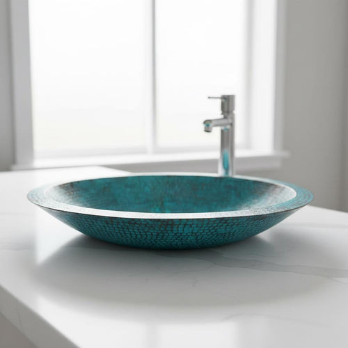 Turquoise copper sink on a white countertop with a blurred window background