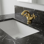 Gold faucet on a black marble countertop with a white sink.