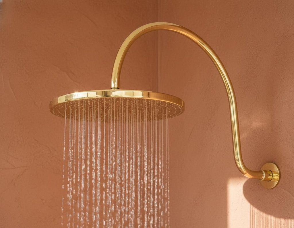 Unlacquered solid brass gooseneck shower arm with round rainfall showerhead for a luxurious bathroom finish