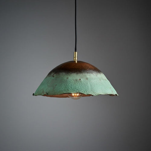 Pendant light with green and brown shade on a gray background