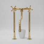 Gold faucet with a white cup on a gray background